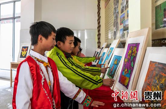 贵州省黔西市锦绣学校举行体育艺术文化节，学生在观看绘画展览。
