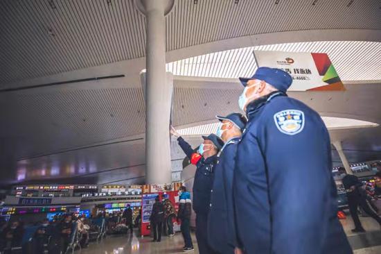 民警会同客运安全员对乌鲁木齐站候车大厅高空遥控水炮进行灵敏度测试。