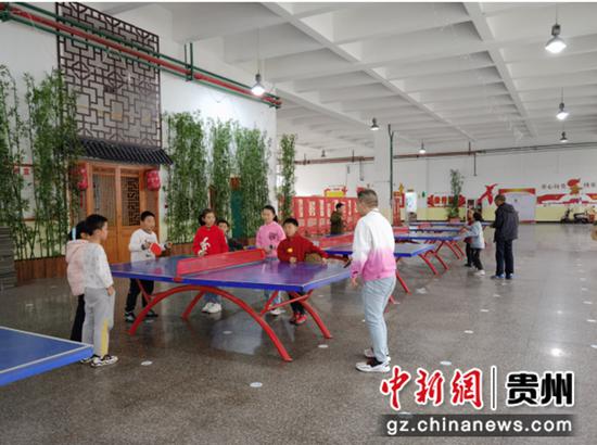 图为贵阳市林泉小学场地开放时家长和孩子一起打乒乓球