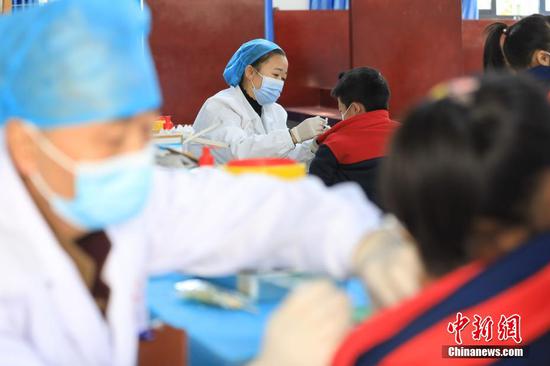 医务人员在为小学生接种疫苗。 瞿宏伦 摄