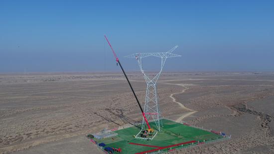 伊犁-博州-乌苏-凤凰II回750千伏输电线路工程开展铁塔组立作业。滚艳 摄