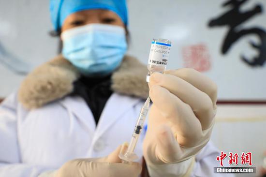 新蒲镇卫生院医务人员在吸取疫苗药液。 瞿宏伦 摄
