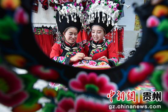 2021年11月17日，人们在贵州省铜仁市松桃苗族自治县大兴街道一家苗族服饰作坊内赶制服饰。