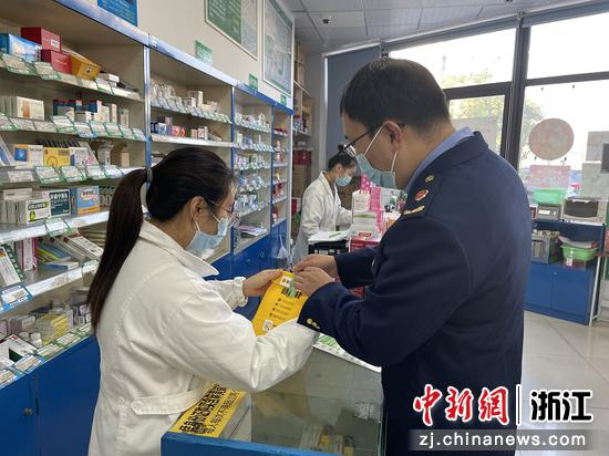 监管人员在指导药店工作人员贴上“药安封签”。胡人杰 摄