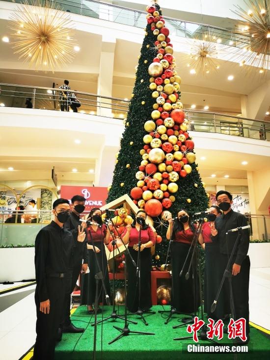 11月21日，菲律宾首都大马尼拉CBD马卡蒂商圈GLORITA商场恢复现场表演，演员们带着口罩吟唱圣诞歌曲。中新社记者 关向东 摄