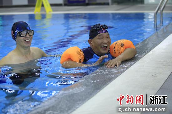 残疾人代表在志愿者的帮助下体验游泳。张华 摄