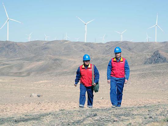 2021年10月5日，国网昌吉供电公司员工马小宝、阿尔曼别克在木垒县采风丝路大石头风电一场排查备用线路安全隐患，保障新能源发电厂供电可靠。何玉成 摄