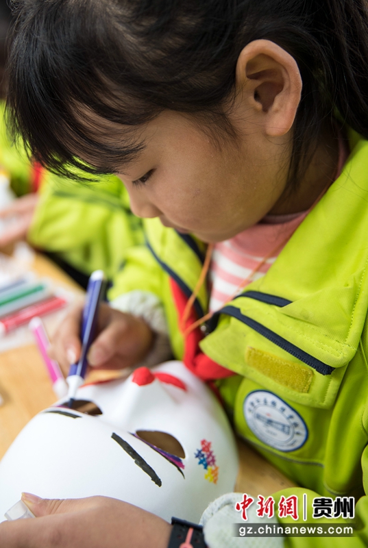 2021年12月4日，贵州省黔西市锦绣花都易地扶贫搬迁安置点农家书屋，孩子们在阅读延伸活动中认真绘制面具。