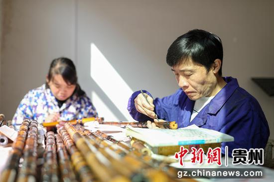 2021年12月4日，姚茂顺（右）在贵州省铜仁市玉屏侗族自治县平溪街道舞阳村箫笛工坊里制作箫笛。