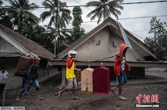 当地时间12月6日，印度尼西亚爪哇岛东部，村民离开Sumber Wuluh 村。据报道，塞梅鲁火山喷发造成的死亡人数已升至14人，另有56人受伤，其中35人伤势严重。已有至少1300人被迫转移。