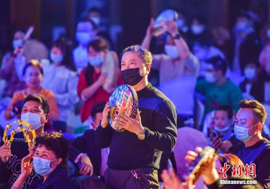 12月1日晚，新疆烏魯木齊大巴扎宴藝大劇院恢復《絲綢之路千年印象》演出，并推出優惠票價。據介紹，受新冠肺炎疫情影響，該劇院曾兩度暫停演出。圖為臺下觀眾打起手鼓參與互動。 中新社記者 劉新 攝