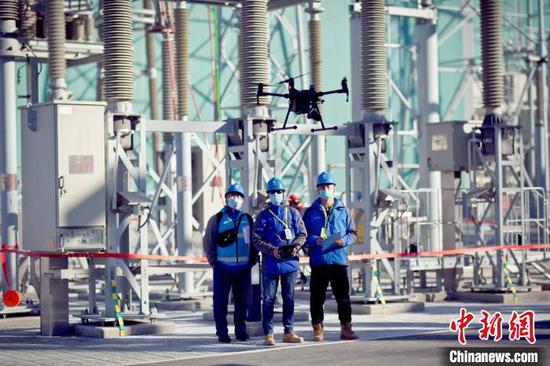 在±1100千伏昌吉换流站内，工作人员用无人机巡查站内设备。　周欢 　摄