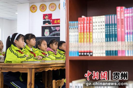 2021年12月4日，贵州省黔西市锦绣花都易地扶贫搬迁安置点农家书屋，孩子们聚精会神地听知名阅读推广人讲故事。