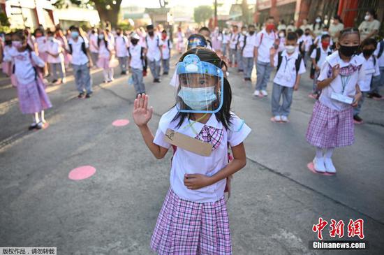 当地时间12月6日，菲律宾马尼拉，学生们在上课前参加升旗仪式。据报道，这是菲律宾首都马尼拉自新冠肺炎疫情以来首次复课。