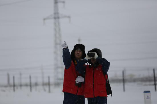 12月14日国网哈密供电公司员工冒雪对110千伏马轻线进行特殊巡视保障群众安全用电。冯洋 摄