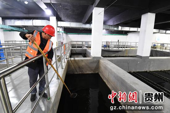 12月15日，贵阳市青山再生水厂的保洁工人正在打捞高效沉淀池中的浮渣。