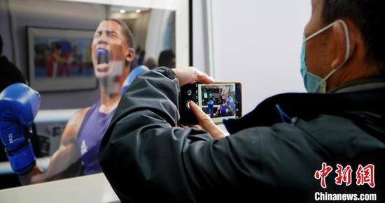图为市民参观奥运体育摄影作品展时拍照记录。　应腾　摄