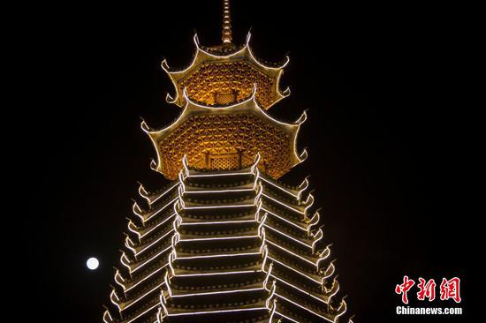 2021年12月19日在贵州省黔东南苗族侗族自治州从江县拍摄的满月。12月19日是农历十一月十六，一轮满月现身夜空，并与侗族鼓楼相映成趣，这是2021年最后一轮满月，也是本年度众多满月当中“最小”的一个。吴德军 摄