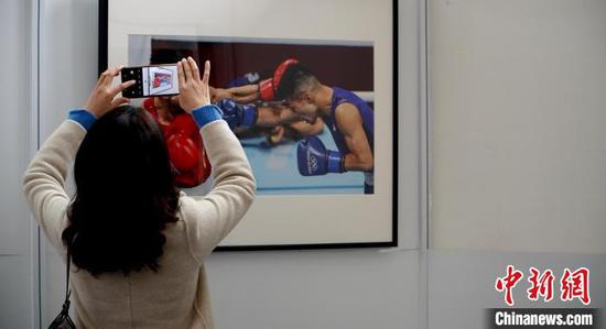 图为市民参观奥运体育摄影作品展时拍照记录。　应腾 摄