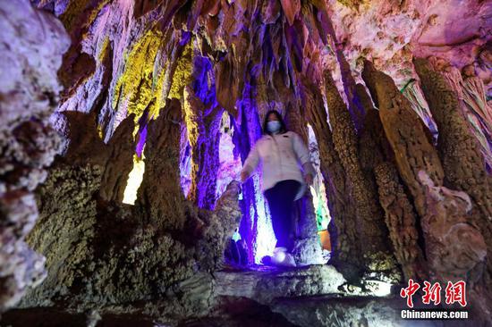 12月24日，游客在“万佛洞”内游览。“万佛洞”位于贵州省遵义市绥阳县枧坝镇，其海拔高度1100余米，全长880余米，是一个高山溶洞景区。“万佛洞”分布18个大小不一的洞厅，各类钟乳石、石柱、石笋在洞厅内重叠密布。