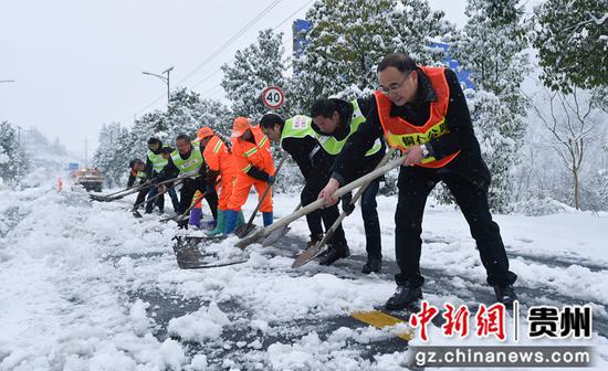 2021年12月26日，贵州省松桃公路管理段的工作人员在贵州省铜仁市松桃苗族自治县的公路上除雪。