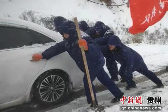 轿车雪中被困，致轮胎打滑，消防员积极助力。万山消防供图