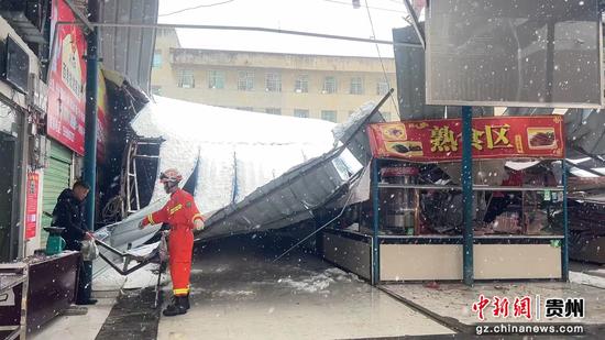 图为德江一菜市场被积雪压塌，消防员正在排查隐患中。德江消防供图
