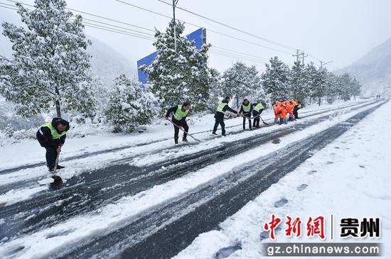 2021年12月26日，贵州省松桃公路管理段的工作人员在贵州省铜仁市松桃苗族自治县的公路上除雪。