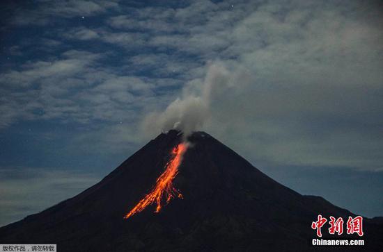 当地时间12月26日，印度尼西亚默拉皮火山喷发，烟雾缭绕，熔岩顺着山体流淌。