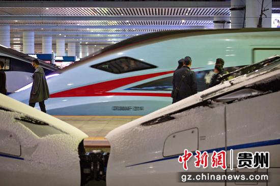 12月26日,贵州迎来隆冬第一场降雪，贵阳车站工作人员全员到岗确保设备设施运行正常,在贵阳北站站台上旅客正有序上下车。 张贵忠 摄