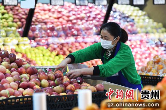 12月27日，在贵阳市南明区惠民生鲜合力超市南浦路店，工作人员正在整理果蔬区的水果。
