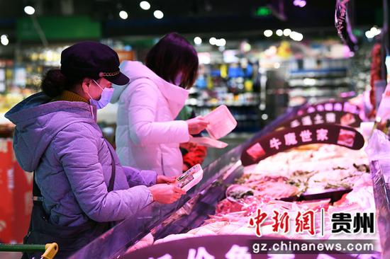 12月27日，消费者在贵阳市南明区惠民生鲜合力超市南浦路店选购鲜肉。