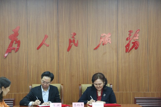 阿勒泰地区人大工委党组成员、副主任巴合提古丽·热合买多拉（右）与博州人民政府副州长方向荣（左）签订了“新疆人游新疆”合作协议书。