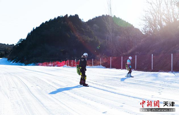 图为玉龙滑雪场游客在朝阳下滑雪。 王在御 摄