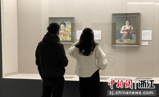 展览现场，观众在欣赏油画时互相交流探讨。 童笑雨 摄