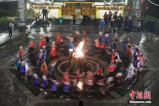 2021年12月31日晚，贵州省黔西南布依族苗族自治州普安县茶源街道，少数民族同胞举行篝火晚会，迎接2022年到来。 中新社记者 瞿宏伦 摄