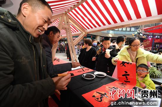 1月1日，在贵阳市南明区举办的“非遗进社区 文化共传承”元旦主题活动现场，书法爱好者正在给市民书写春联。
