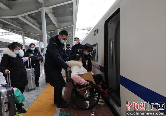 图为桂林火车站客运值班员王海涛将轮椅旅客平安送入车厢。郑长贤 摄