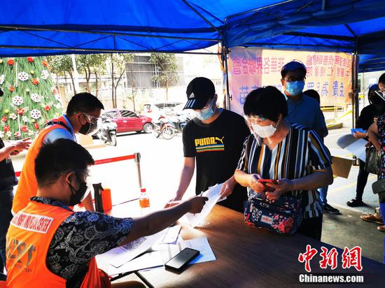 志愿者在为接种者发放登记表格。 中新社记者 关向东 摄