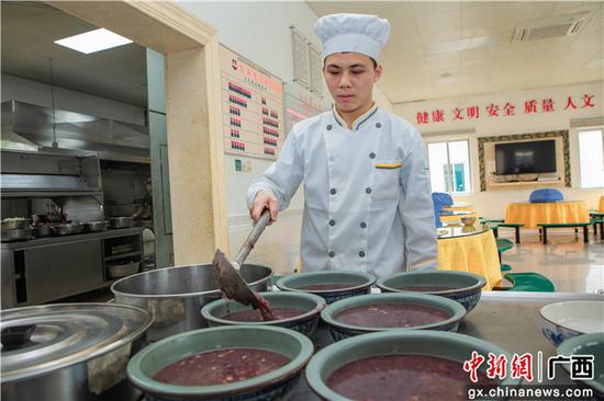 1月9日，武警官兵将熬制好的腊八粥装碗。刘明  摄