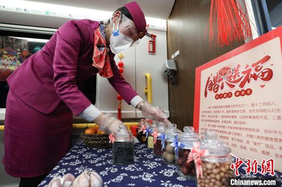 贵州省毕节市，C5980次列车列车员在摆放腊八粥原材料展品。　瞿宏伦 摄