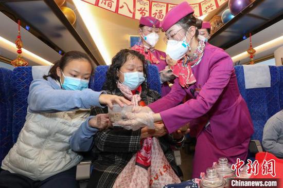 贵州省毕节市，C5980次列车列车员在给旅客发放腊八粥。　瞿宏伦　摄