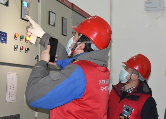 国网乌鲁木齐供电公司共产党员服务队队员检查校园配电室。