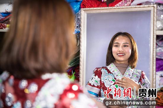 2022年1月11日，贵州省黔西市林泉镇高锦社区一家苗族服饰加工车间，苗族姑娘试穿成品新服饰。