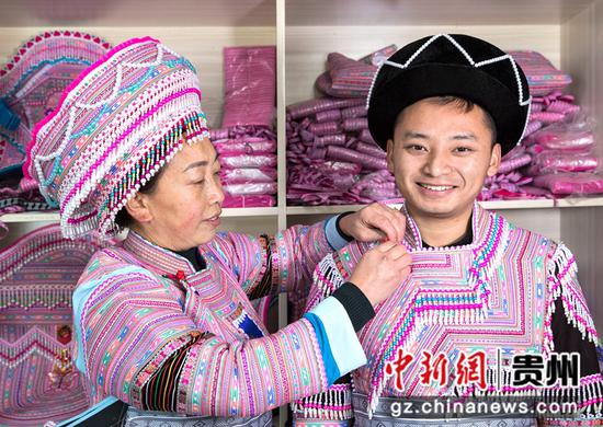 2022年1月10日，贵州省黔西市红林彝族苗族乡鱼塘村一家苗族服饰加工车间，苗族小伙购买服饰、试穿服饰。