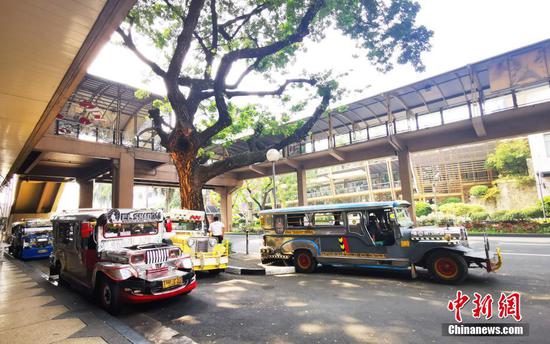 1月10日，菲律宾首都马尼拉CBD马卡蒂绿带商圈，多辆吉普尼在路边等待，生意萧条。菲律宾卫生部发布消息称，截至1月10日16时，菲律宾单日新增33169例新冠肺炎确诊病例，再次突破该国疫情暴发以来单日新增病例最高纪录。 中新社记者 关向东 摄