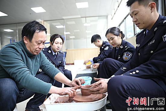 图为民警在陶艺师指导下操作拉胚，完成瓷器成型的第一道工序。甘勇 摄