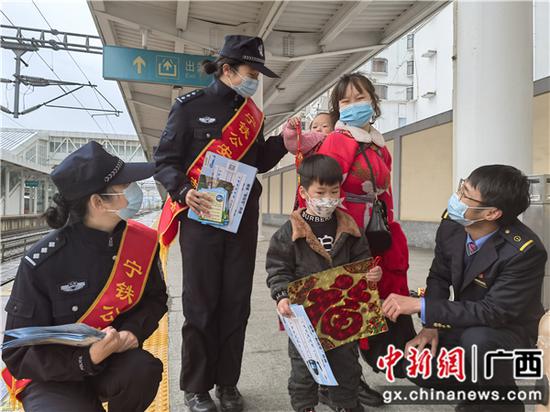 春运首日，桂林站派出所民警向旅客普及安全乘车知识并赠送“福”字。李俐 摄