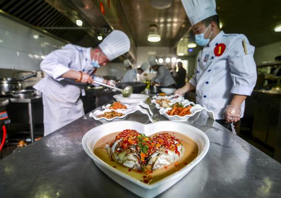 参赛选手用当地的野生鱼烹饪美食。 中新社记者 刘新 摄