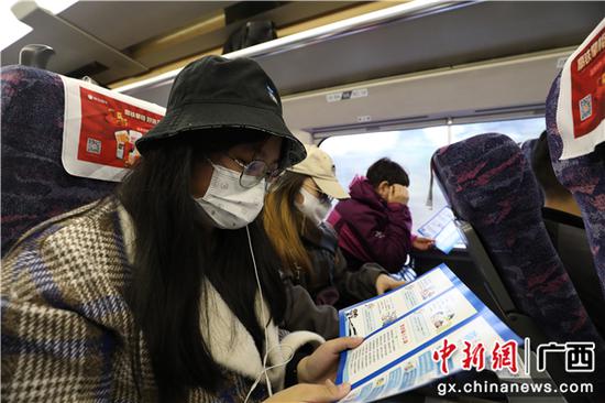 旅客认真阅读反诈手册。